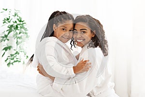 Home Portrait Of Happy Loving Black Family Mother And Daughter In Bathrobes