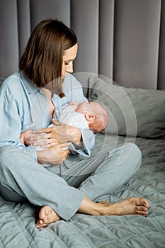 Home portrait of a newborn baby with mother on the bed.