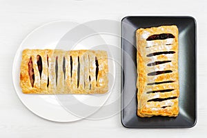 Home puff pastry with berries on white wooden table.