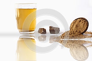 Home remedy to reduce headache or to treat headache isolated on white i.e. Hing or Devil`s dung powder well mixed in water with photo