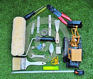 Home renovation and construction concept with work tools in house shape on the grass