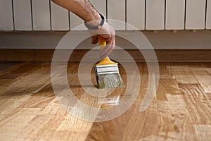 Home renovation parquet. Varnish paintbrush strokes on a wooden parquet