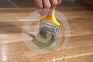 Home renovation parquet. Varnish paintbrush strokes on a wooden parquet