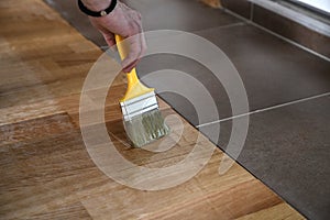 Home renovation parquet. Varnish paintbrush strokes on a wooden parquet