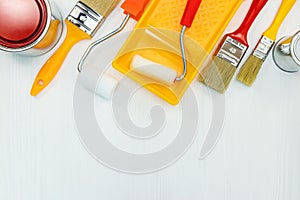 home renovation. set of paint brushes and rollers on white wooden background