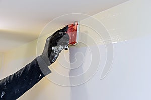 Home renovation on working contractor painter hands with painting the wall on corner paint edger