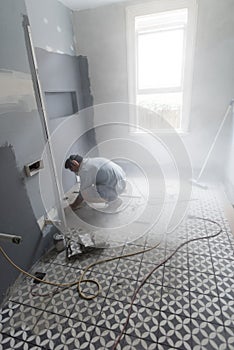 Home renovator cutting into the bathroom wall