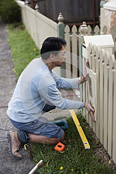 Home renovator installing a new mailbox