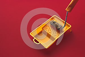 Home Repair Creativity Concept. Roller For Paint And Painting Capacity On Red Background Surface