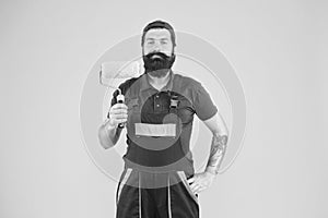 Home repair worker. bearded man worker with roller tool. hipster builder in cap yellow background. erector assistant in photo