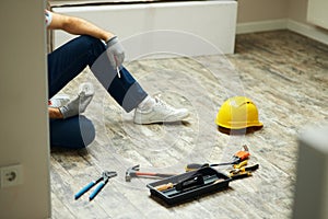 Home repairs. Cropped shot of handyman holding screwdriver and wall plug socket. Home repair hand tools on laminate