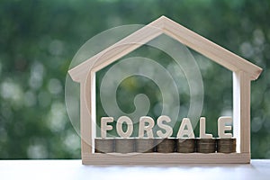 HOME FOR SALE,Model house and stack of coins money on natural green background,Business investment and real estate concept