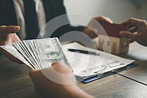 Home sales brokers and real estate investors are exchanging with investors being filing cash at the agent`s hand photo