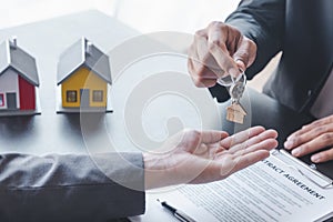 Home sales,home rental and real estate concept.Hands of estate agent giving keys to the Customer after sign the document while