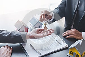 Home sales,home rental and real estate concept.Hands of estate agent giving keys to the Customer after sign the document while