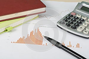 Home savings, budget concept. Chart, notepad, pen, calculator and coins on wooden office desk table.