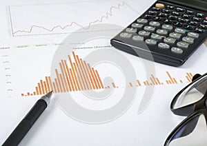 Home savings, budget concept. Chart, pen, calculator and glasses on wooden office desk table