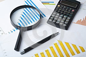 Home savings, budget concept. Chart , pen, calculator and magnifying glass on wooden office table.