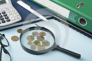 Home savings, budget concept. Notepad,magnifying glass, calculator and coins on wooden office desk table