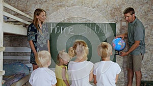 Home school concept. Parents teach their children with a globe in their hands.