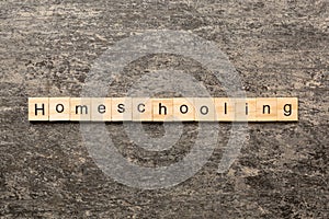 Home schooling word written on wood block. Homeschooling text on table, concept