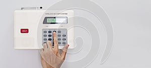 Home security system, Hand entering code on home security keypad, on white wall with copy space