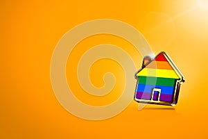 Home shape with gay pride rainbow  on orange background, copy space. Gay people right to live together concept. 3D