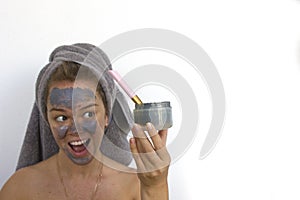 Home Spa Surprised Woman applying Facial clay Mask