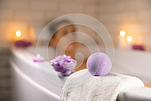 home spa. woman relaxing in bathtub in candle light and using bath bomb and sea salt crystals for body skin moisturizing