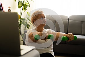 Home Sport. Active Senior Woman Doing Warming Stretching Exercises In Front Of Laptop, Training With Online Tutorials