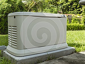 A Home Standby Generator installed at the backyard of a house. An air-cooled natural gas or liquid propane generator for