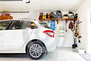 Home suburban car garage interior with wooden shelf , tools and equipment stuff storage warehouse on white wall indoors