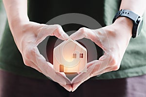 Home sweet home. Heart shape hand holding wooden home. Small house with love