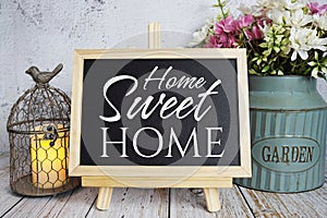 Home Sweet Home text message on blackboard standing on wooden background