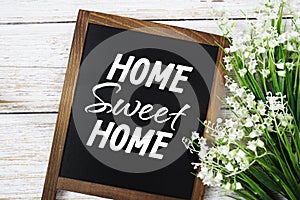 Home sweet home text message with flower decoration on wooden background