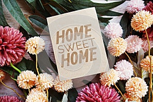 Home Sweet Home text message with flower decoration on wooden background