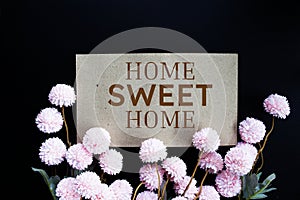 Home sweet Home text message with flower decoration on wooden background