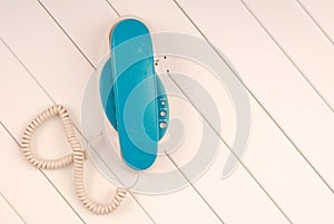 Home telephone is on white background, blue phone device is on t photo