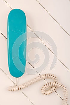 Home telephone is on white background, blue phone device is on t photo