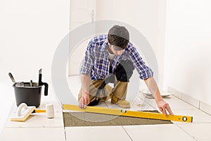 Home tile improvement - handyman with level
