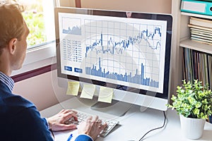 Home trader analyzing forex trading charts on computer screen investment