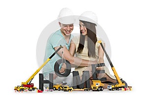 Home under construction: Overjoyed couple with machines building