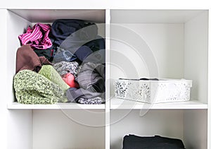 Home wardrobe with different clothes. Small space organization. The contrast of order and disorder