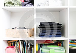 Home wardrobe with different clothes. Small space organization. The contrast of order and disorder