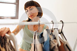 Home wardrobe or dressing room of a clothing store. a young woman chooses a fashionable outfit in her closet at home or in a store