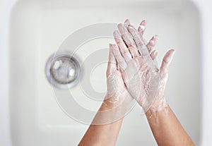 Home, washing hands and person with hygiene, foam and healthy with habit, cleaning and virus protection. Sink, skin care