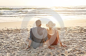 Home is where the waves crash. Rearview shot of a middle aged couple watching the sunset on the beach.