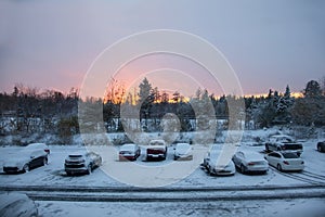 Home in winter parking lot with sunset