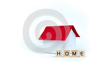 Home- word composed fromwooden blocks letters on red background, layout of a house with a red roof. copy space for ad photo