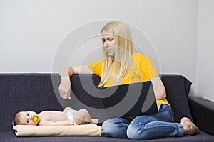 Home Working. Portrait of Young Caucasian Mother WIth Baby Boy Working Remotely Using Laptop